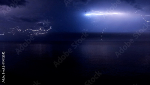 Lightening Storm Cloud-to-air lightning large bolts streaking across the night sky in a dramatic storm over the ocean