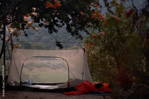 Cuadro en lienzo Serene outdoor camping at dusk with person in sleeping bag near tent in nature s