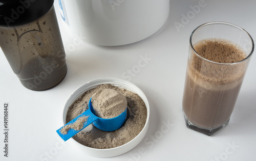 Fotografie Protein shake in a glass and whey protein powder in a measuring scoop