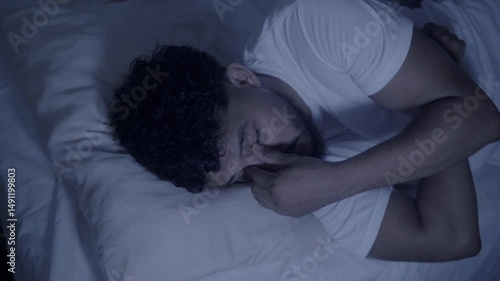 Man struggling with sleep and insomnia in bed