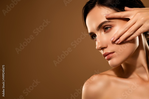 Canvas Print Portrait of a young brunette woman with flawless skin on a beige background