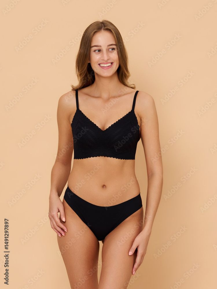 Girl model in underwear posing in studio on beige background. Girl model in underwear posing in studio on beige background.