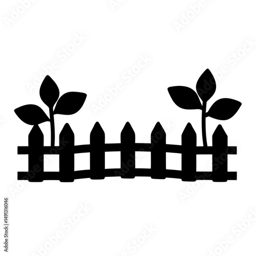 Black and white silhouette of a picket fence with plants growing behind