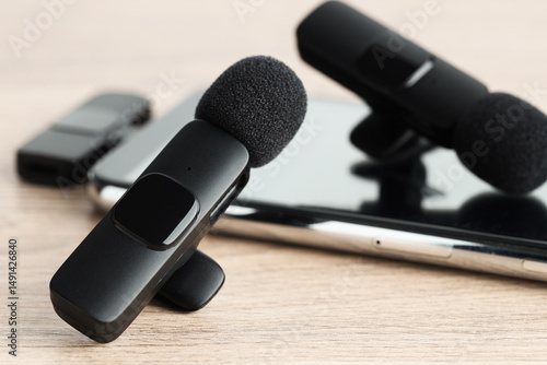 Cuadro en lienzo Lavalier microphones and smartphone with wireless receiver on wooden table, clos