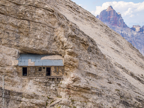 Historical Buffa di Perrero alpine shelter built into a steep rock face during WWI, Monte Cristallo, Dolomites, Italy