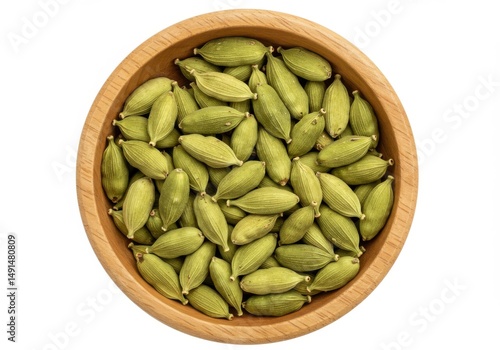 A wooden bowl filled with a generous amount of aromatic cardamom pods viewed above