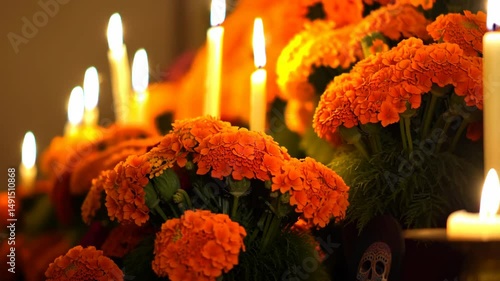 Illuminated altar with burning candles and bright orange flowers for a festive celebration of Dia de los Muertos