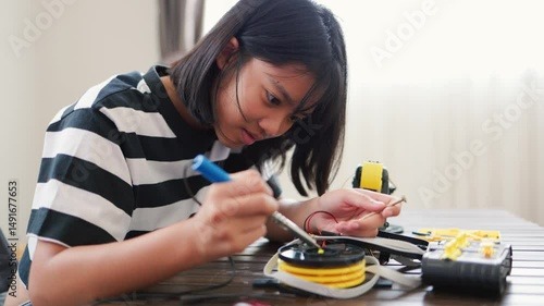 Wallpaper Mural Asian girl assembling robotic arm at home. Promoting STEM education, coding, engineering, and problem-solving skills. Hands-on tech learning for future innovators and young engineers. Torontodigital.ca