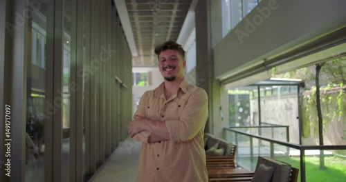 Wallpaper Mural Full body portrait of young man in office corridor with arms crossed, laughing in relaxed and positive mood, casual and confident presence in professional business setting Torontodigital.ca