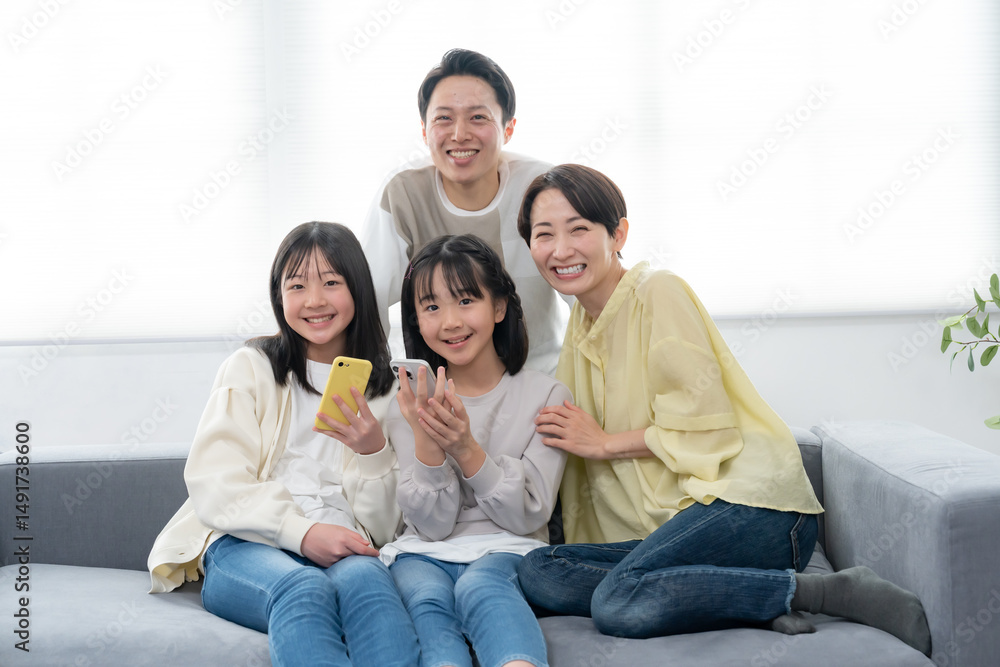 笑顔で携帯を持ちカメラ目線の親子 笑顔で携帯を持ちカメラ目線の親子