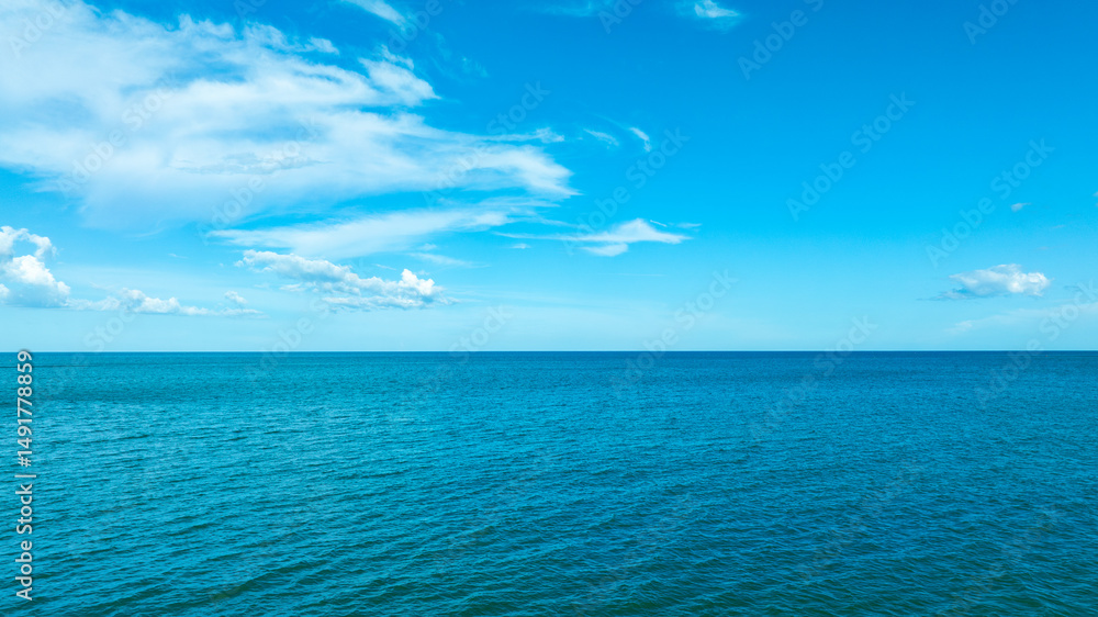 Obraz premium Nature of the ocean and blue sky Summer with sunshine, sandy beaches, clear blue waters sparkling against the blue sky. on an island with good ecology and environment Background for summer vacation