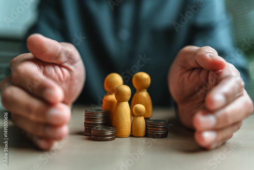 Businessman's hand gestures to protect money and wooden dolls represent family. Image represents the concept of asset protection, emphasizing safeguarding financial investments and property