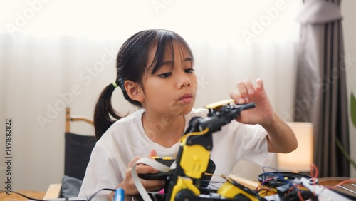 Wallpaper Mural Asian girl assembling robot parts at home, learning STEM and electronics. Developing engineering skills, logical thinking, and problem-solving through hands-on coding education for kids. Torontodigital.ca