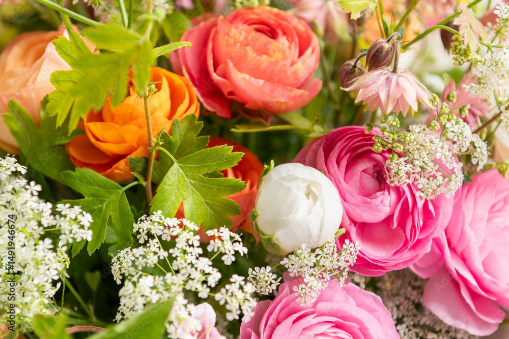 Fototapeta premium Spring mixed ranunculus bouquet. Beautiful pastel colored fresh flowers arrangement. Birthday bouquet made of ranunculus photographed outdoors.