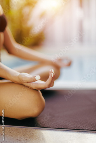 Wallpaper Mural Young caucasian female practicing meditation outdoors by poolside at sunset Torontodigital.ca