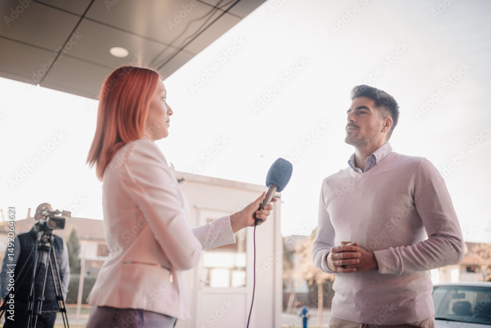 Obraz premium Journalist interviewing businessman holding microphone outdoors