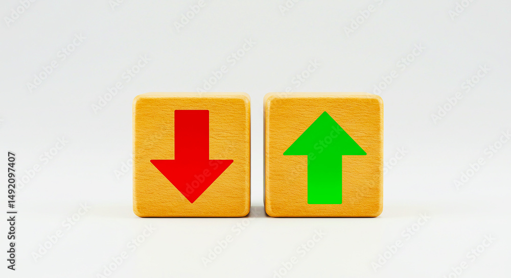 Two wooden blocks displaying a red downward arrow and a green upward arrow on a white background Two wooden blocks displaying a red downward arrow and a green upward arrow on a white background