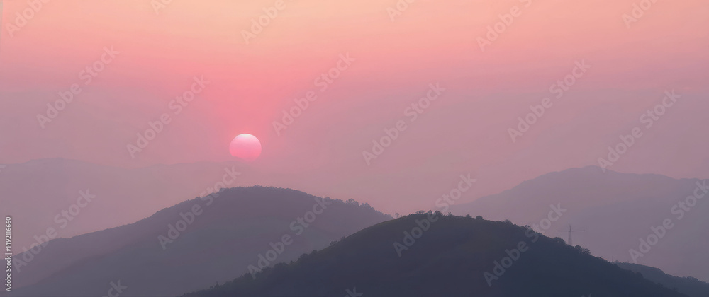 Fototapeta premium Pink and pastel sunrise illuminating misty mountain ridges