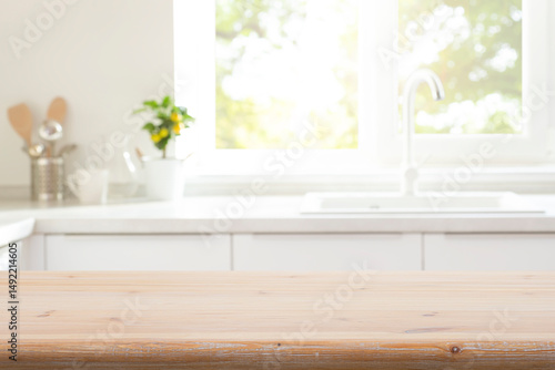 Old wooden table top for product montage on blur kitchen counter with utensils, sink and window interior background