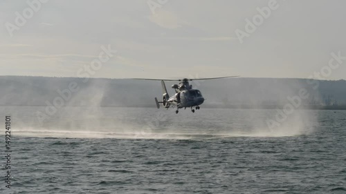 Coast Guard rescuers jump from a helicopter hovering over the sea, on-board rescuers, training for rescue in extreme conditions