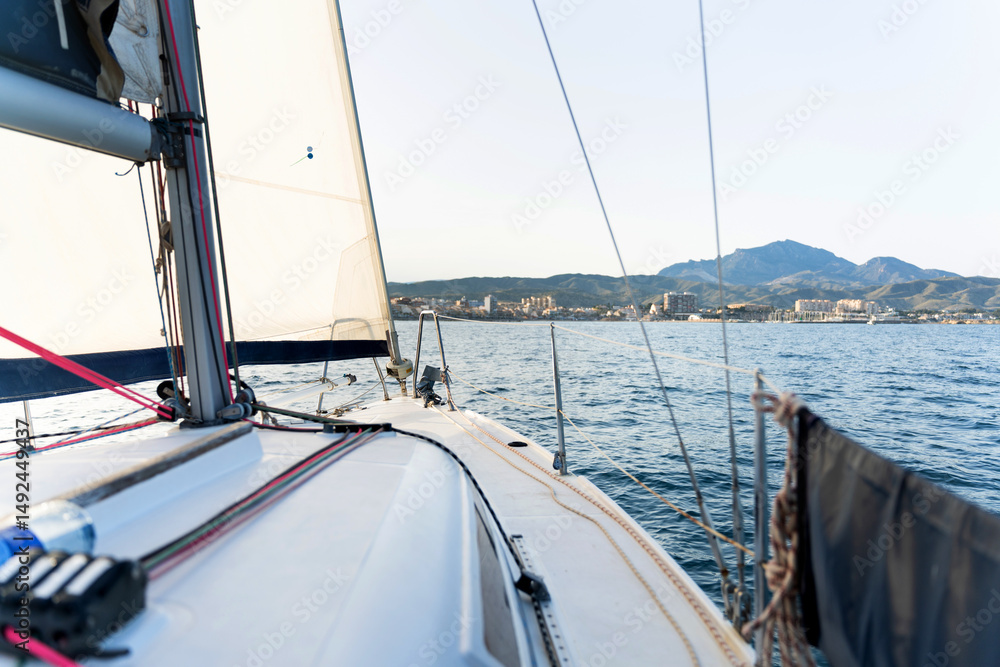 Fototapeta premium Sailboat sailing near the coast on a sunny day