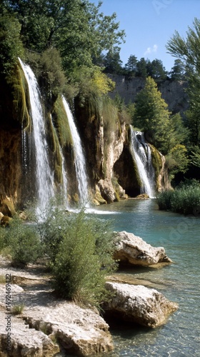 Waterfall cascading down cliffs into a serene lake, ideal for nature, travel, and tourism brochures