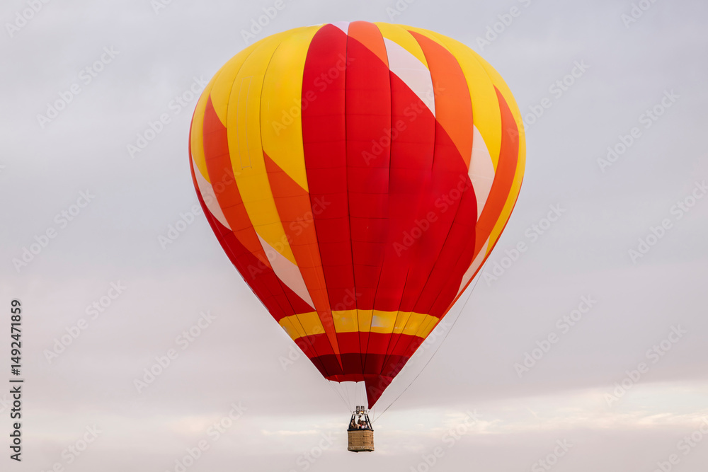 Fototapeta premium Brightly colored hot air balloon rises gracefully