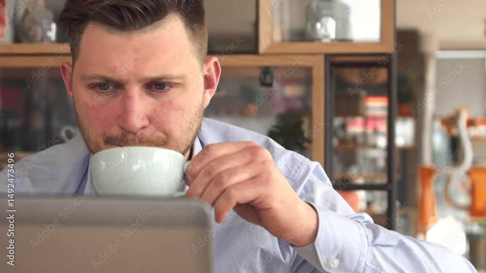 Focused young businessman enjoying coffee while working at a cafe Focused young businessman enjoying coffee while working at a cafe