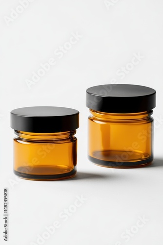 Two amber glass jars with black lids on a white background studio shot minimalist style container mockup