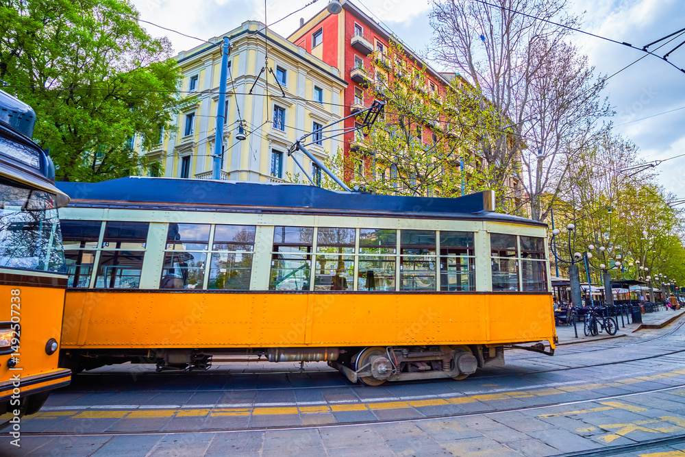 Naklejka premium Vintage trams roll by Corso Sempione in Milan, Italy