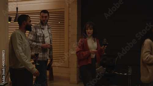 Wallpaper Mural A group of four friends walk and talk while holding glasses, then sit on a sofa and one of them picks up a guitar Torontodigital.ca