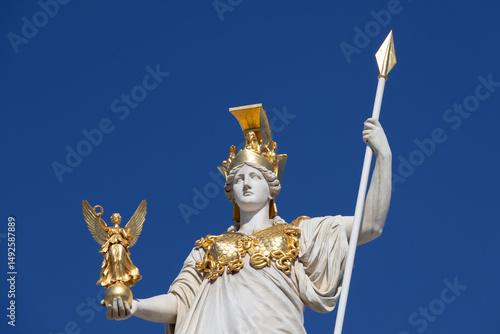Close-up of the Athena Pallas statue with golden accents, part of the Pallas Athena Fountain in front of the Austrian Parliament Building in Vienna.