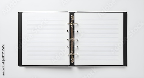 A binder with open rings and lined paper inside, laid on white surface