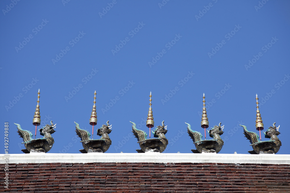 Fototapeta premium Ornate Temple Roof with Mythical Creatures Against Clear Blue Sky