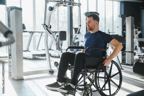 Man in wheelchair exercising in a modern gym for rehabilitation