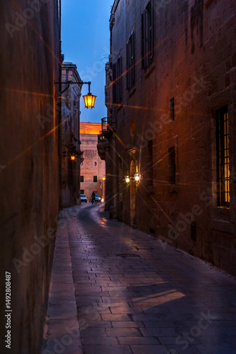 Beautiful view of ancient narrow medieval street town Mdina, Malta. Twilight.