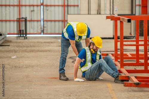 Photography A worker in a hard hat is injured and being helped by another worker