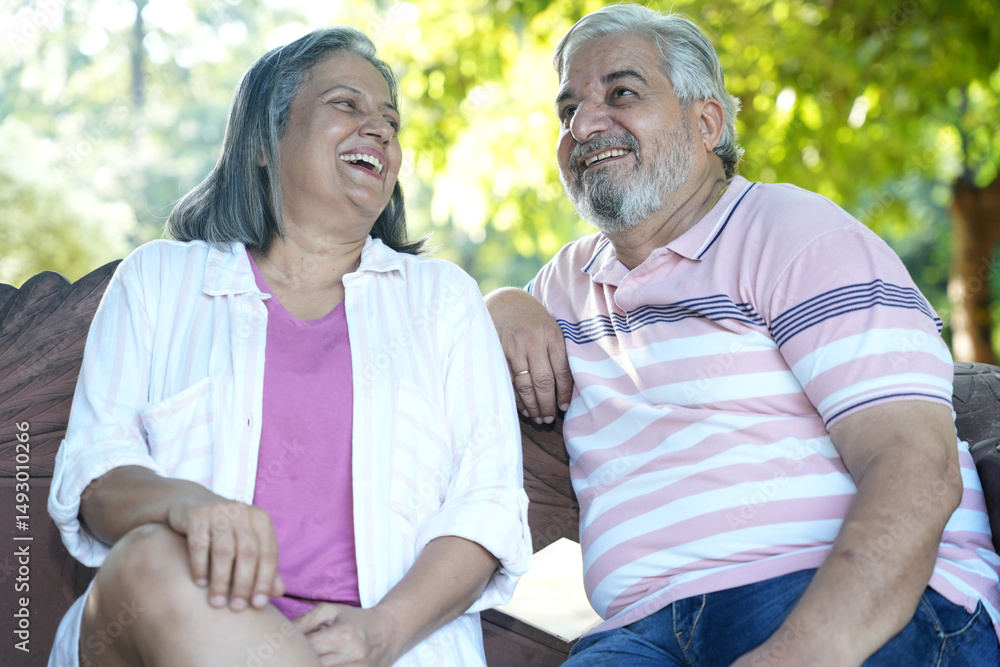 Fototapeta premium Indian Happy Senior Couple having fun and spending quality leisure time in vacation time after retirement at park. Concept of senior citizen living