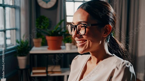 a person smiling in the room, wearing glasses and in the office. A good mood for the day 