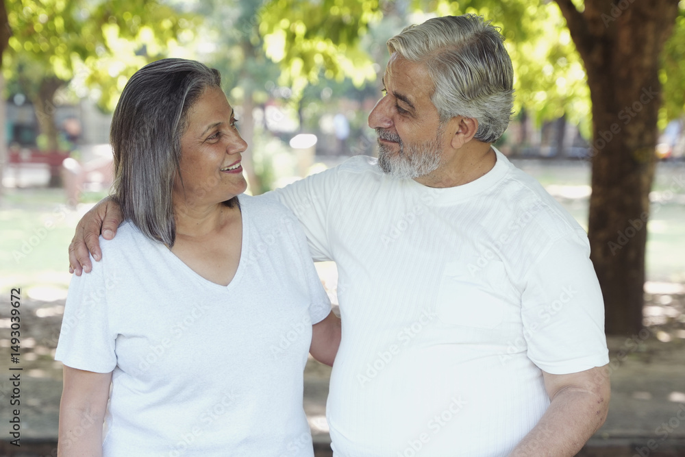 Fototapeta premium Indian Happy Senior Couple having fun and spending quality leisure time in vacation time after retirement at park. Concept of senior citizen living