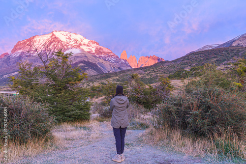 Sunrise view of Torres del Paine peaks. Woman watching. Patagonia, Chile.