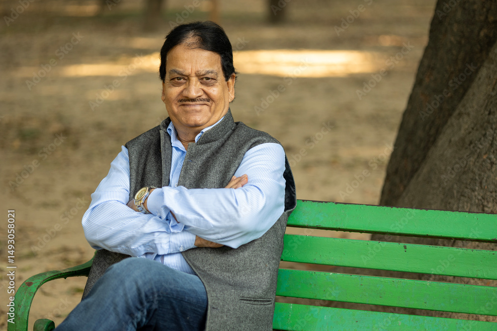 Indian happy Senior man sitting and smiling at park Indian happy Senior man sitting and smiling at park