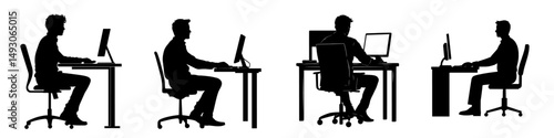 A man is seated on an office chair at a table, working on a computer