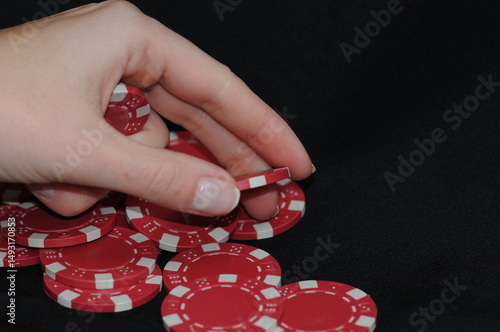 Hand Picking Up Red Casino Poker Chip
Close-up shot of a human hand picking up a red poker chip from a pile on a black background.