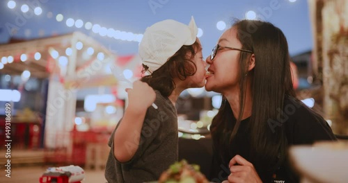 Playful and loving moment of a child sharing French fries with mom, highlighting the deep emotional bond in everyday family life.

