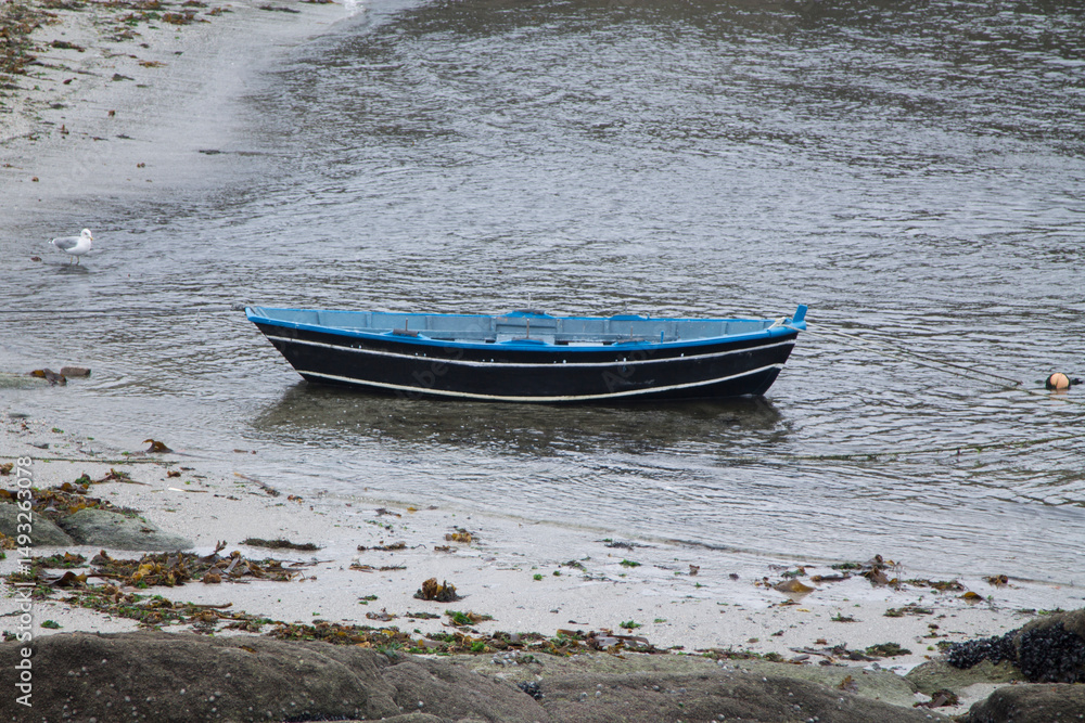 Naklejka premium Blue wooden fishing boat moored at sea