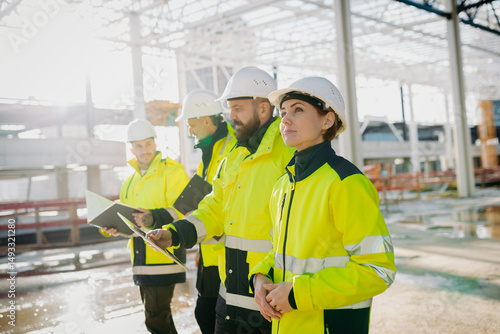 Slika na platnu Team of engineers and construction workers inspecting building progress
