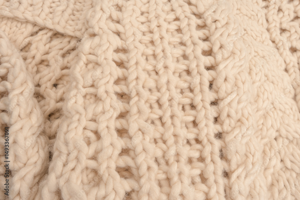 A fragment of beige knitted fabric, knitted from white sheep wool. A fragment of beige knitted fabric, knitted from white sheep wool.