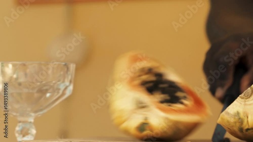 Senegalese Bartender Craft: Macro Close-up of African Hands Slicing Fresh Papayas with Knife, Exotic Fruit Preparation on Bar Counter for Juices Cocktails