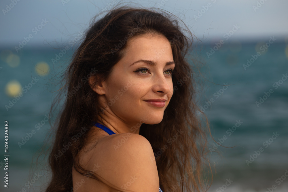 Beautiful happy smiling brunette woman in blue bikini looking on blue sea background. Closeup portrait. Happy vacatins holidays. Natural colors. Without face retouching Beautiful happy smiling brunette woman in blue bikini looking on blue sea background. Closeup portrait. Happy vacatins holidays. Natural colors. Without face retouching